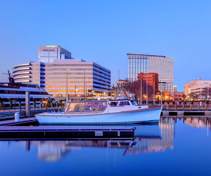 view of Norfolk, Va from the harbor with a boat in the foreground