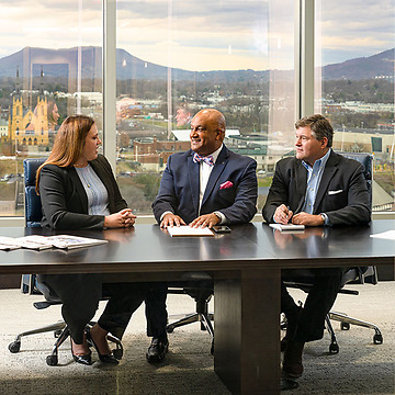 three Woods Rogers attorneys in a Roanoke conference room