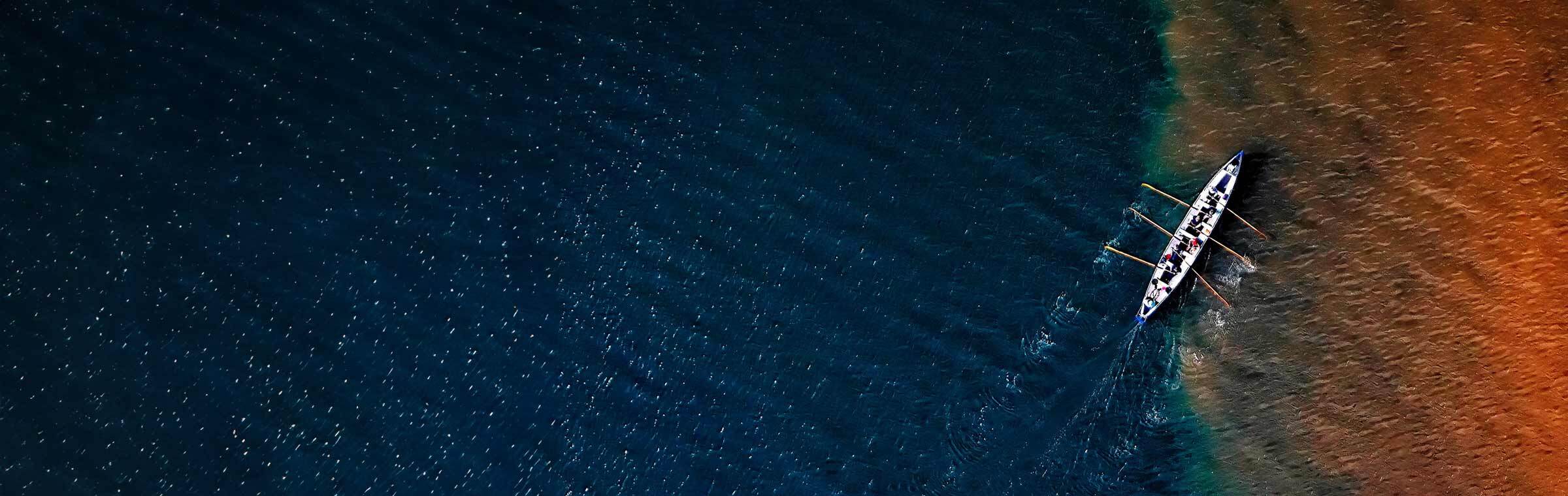 team rowing across dark blue water