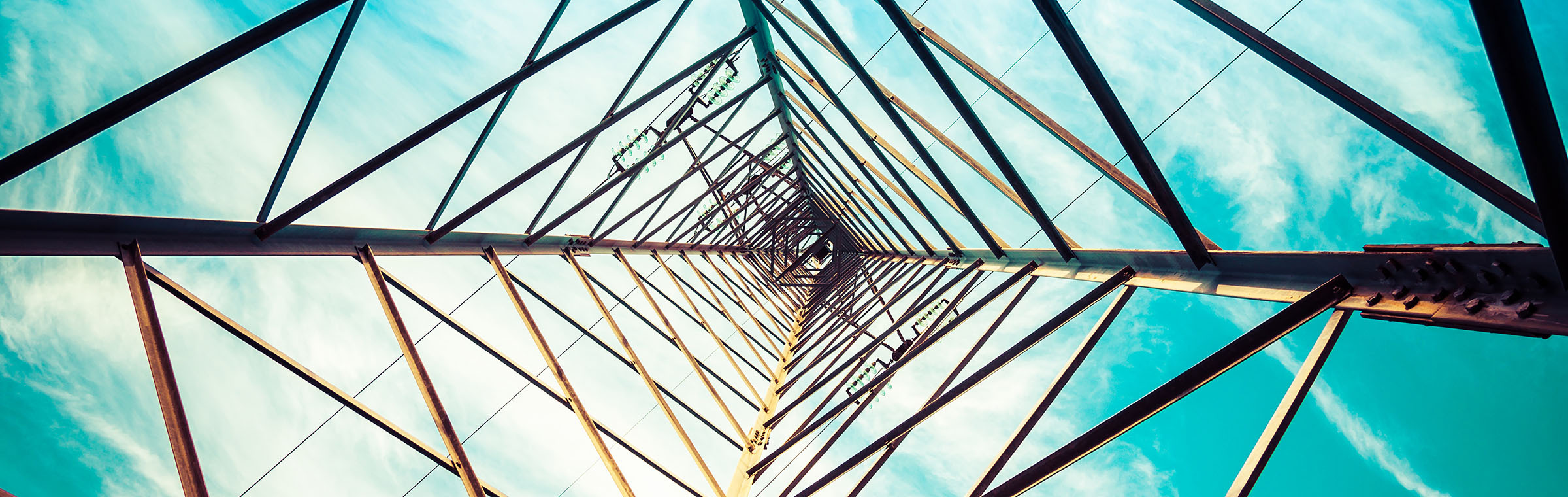 Silhouette shot of electricity pylons with cloudy sky