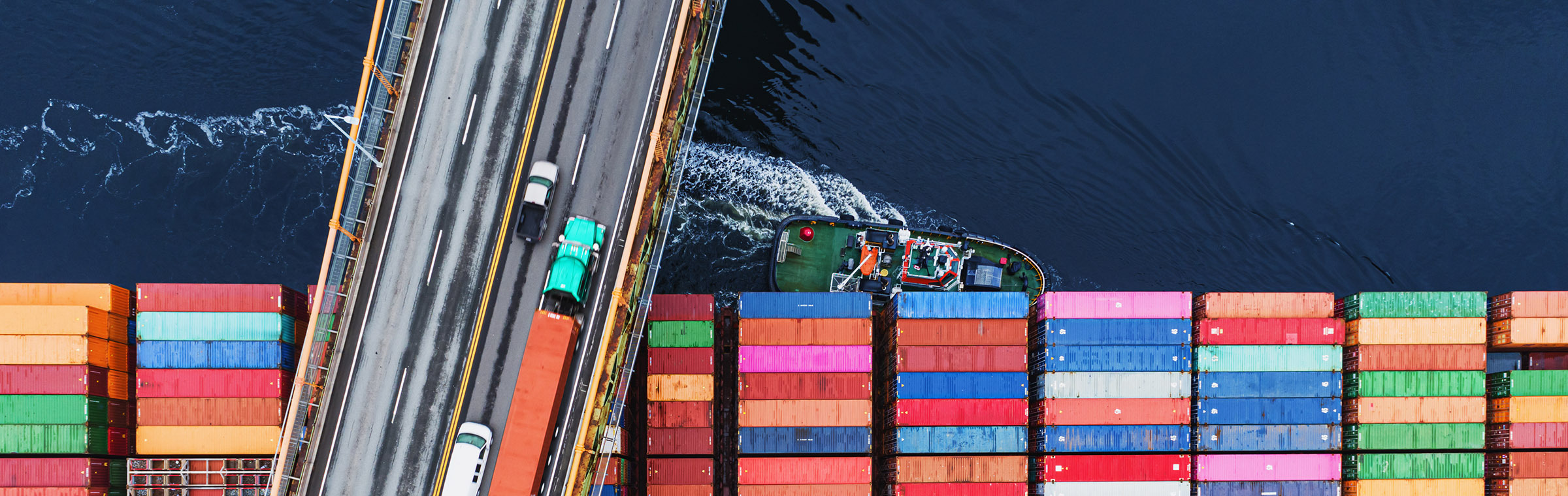 container ship passes beneath a suspension bridge