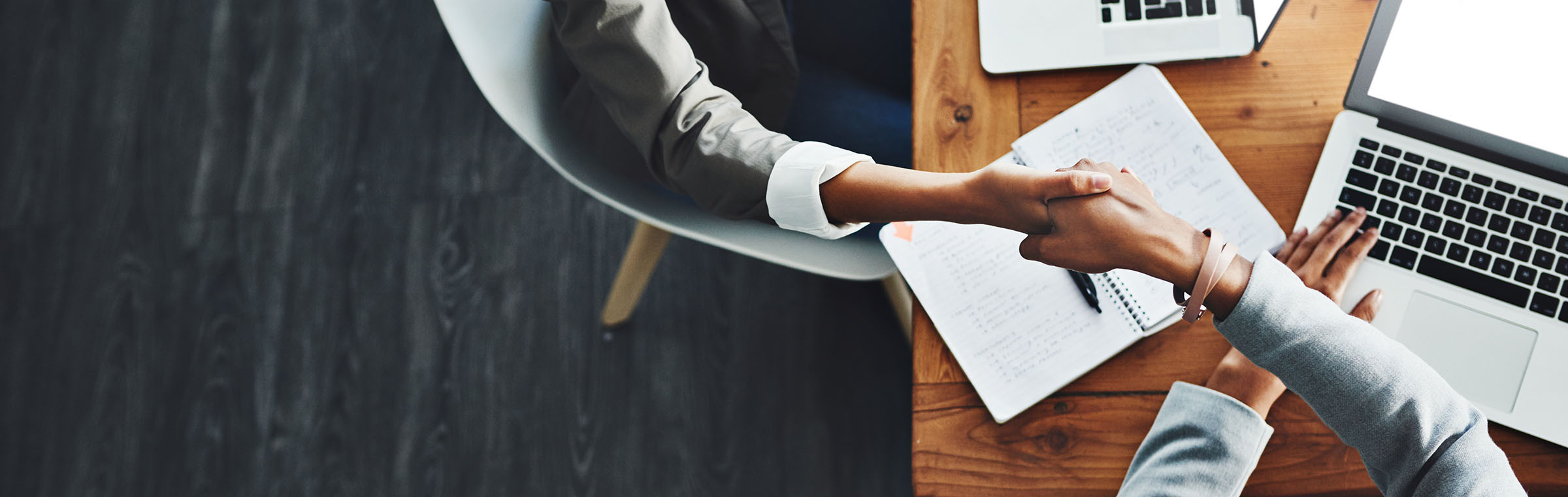 High angle shot of two businesswomen shaking hands in an office